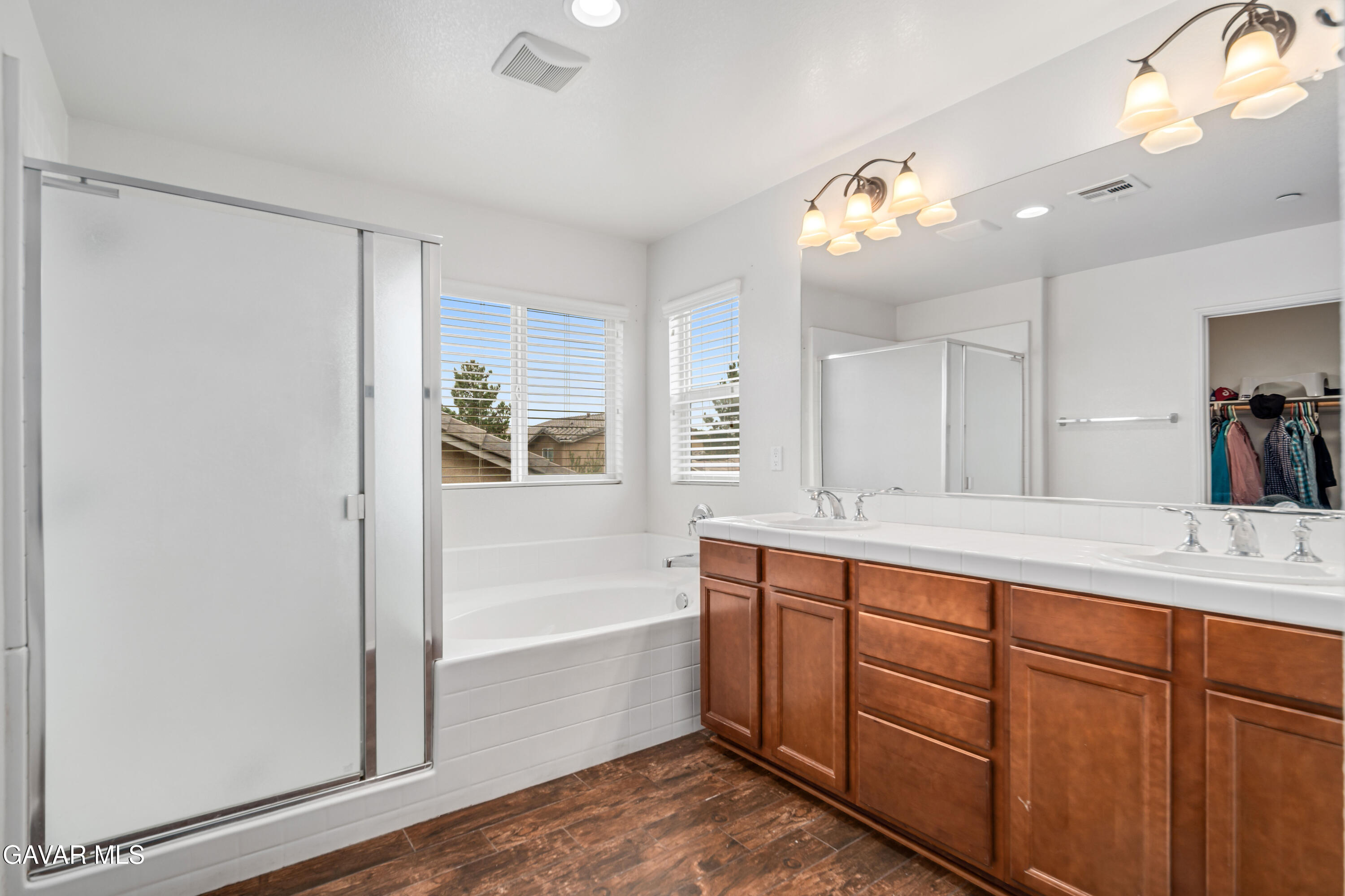 3024 Erica Avenue Rosamond, CA 93560 - Photo 21 of 32 a spacious bathroom with a tub sink and mirror