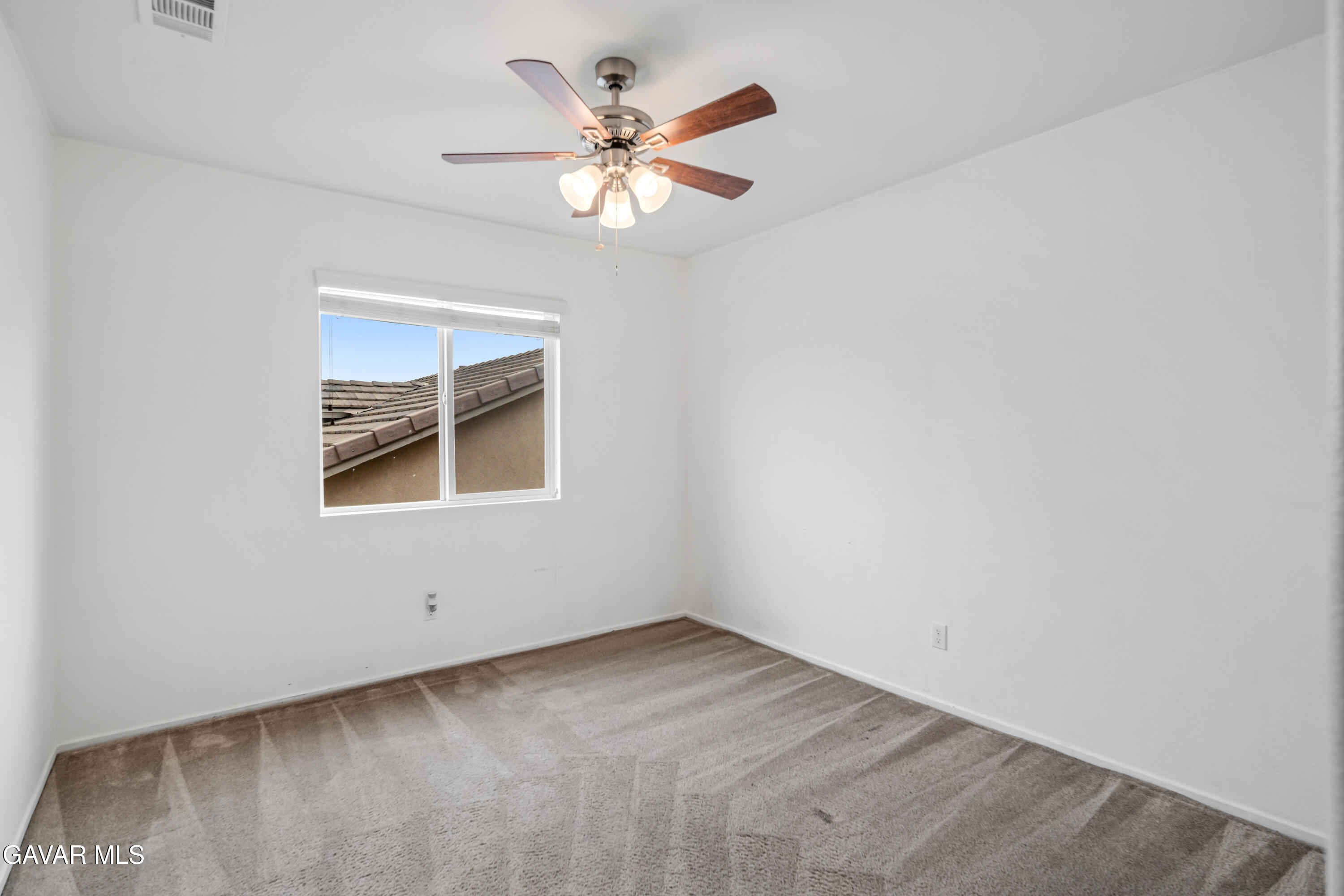3024 Erica Avenue Rosamond, CA 93560 - Photo 23 of 32 an empty room with a chandelier fan and windows