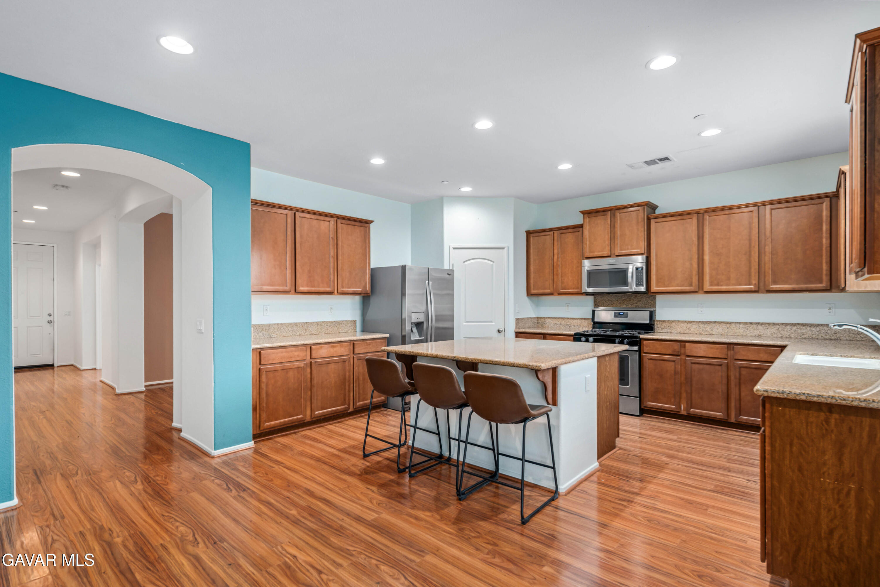 3024 Erica Avenue Rosamond, CA 93560 - Photo 10 of 32 a kitchen with stainless steel appliances granite countertop a kitchen island hardwood floor sink stove dining table and chairs