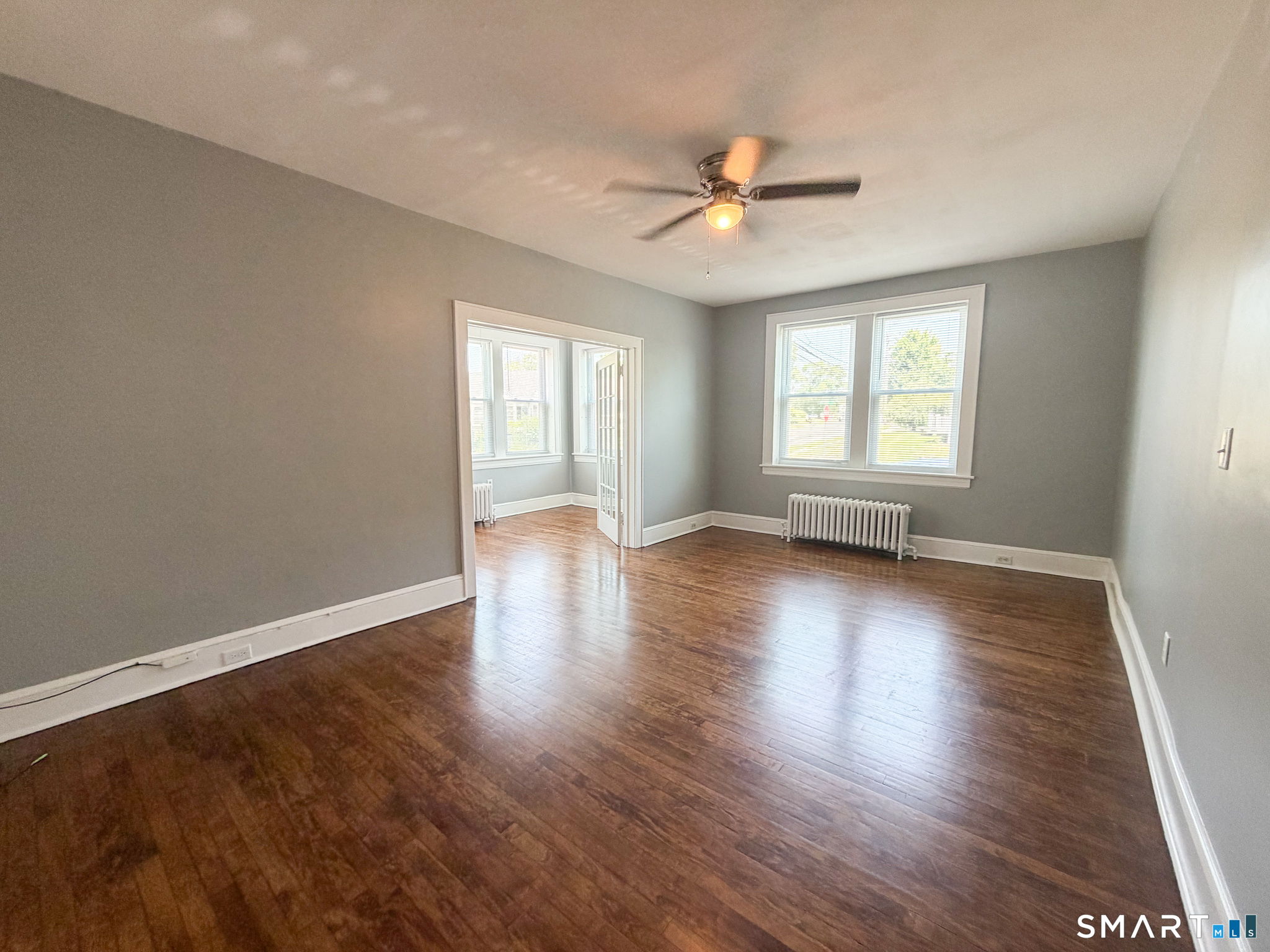 793 Milford Point Road, Unit 1 Milford, CT 06460 - Photo 6 of 16 a view of an empty room with wooden floor and a window