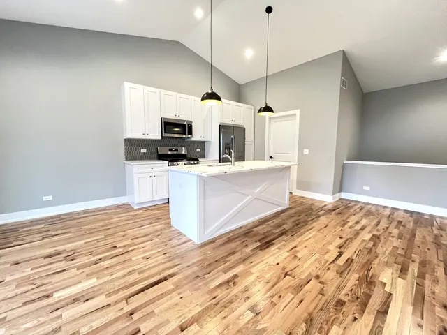 a large kitchen with kitchen island a sink stainless steel appliances and cabinets