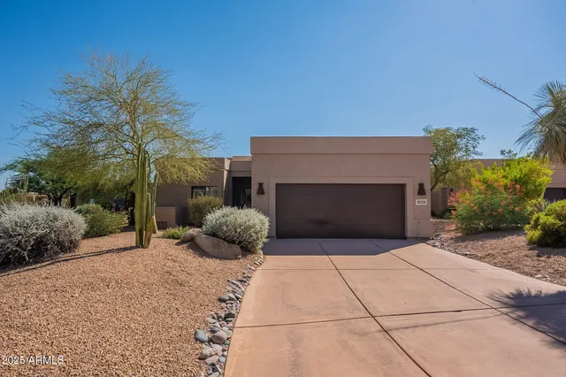 a front view of a house with yard and garage