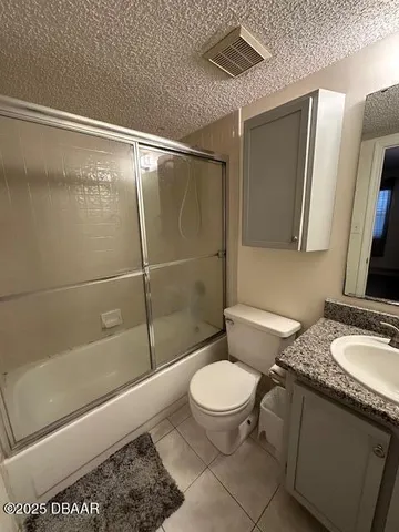 a bedroom with a bed and lamp on dresser