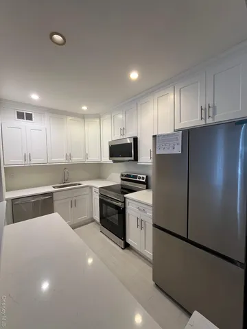 a kitchen with stainless steel appliances granite countertop a refrigerator sink stove and microwave