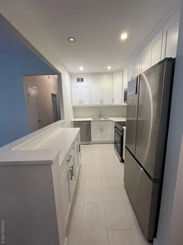 a kitchen with a refrigerator sink and wooden cabinets