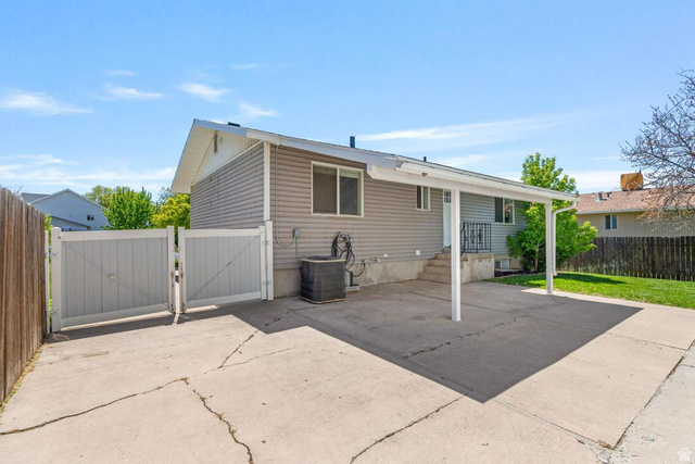 415 East 1150th Street North Logan, UT 84341 - Photo 33 of 38 Exterior featuring light gray siding, a covered carport, and a fenced side yard