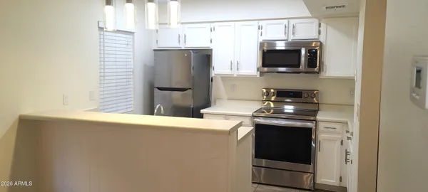 a kitchen with stainless steel appliances a refrigerator a stove a microwave and cabinets