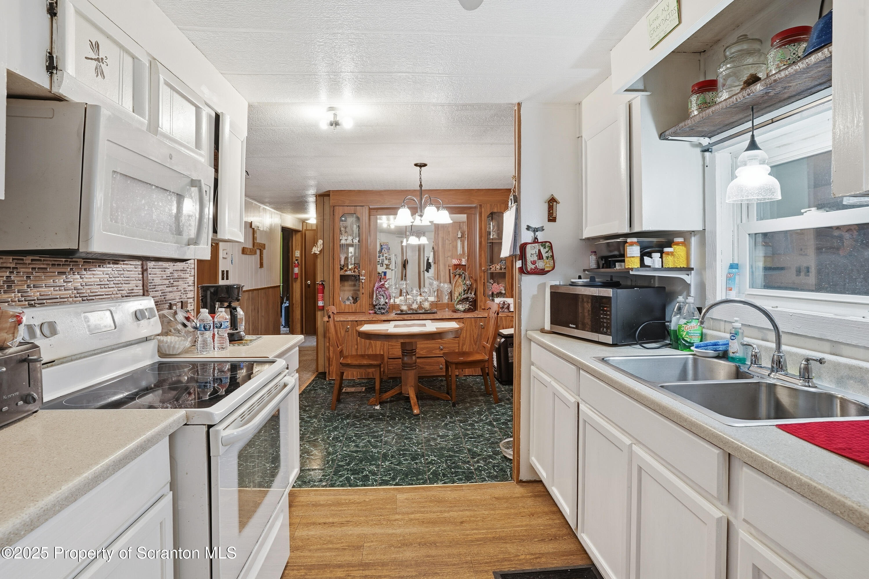 4794 Highway 706 Wyalusing, PA 18853 - Photo 8 of 40 a kitchen filled counter top space a sink a stove and a wooden floors