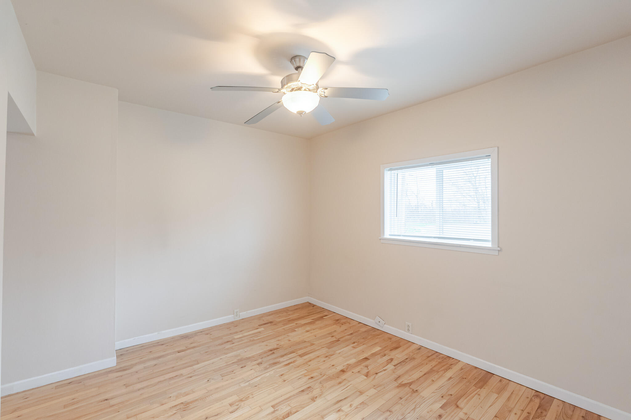 555 South Locust Street, Unit 2 Valparaiso, IN 46383 - Photo 7 of 8 an empty room with wooden floor fan and windows