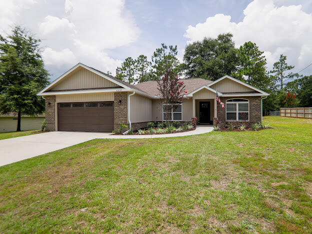 6330 Possum Ridge Road Crestview, FL 32539 - Photo 2 of 22 a front view of a house with a garden and trees