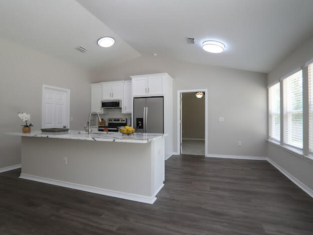 6330 Possum Ridge Road Crestview, FL 32539 - Photo 4 of 22 a view of a kitchen with kitchen island a sink wooden floor and a refrigerator