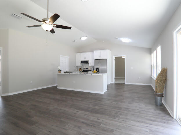 6330 Possum Ridge Road Crestview, FL 32539 - Photo 6 of 22 a view of a kitchen with wooden floor and a ceiling fan