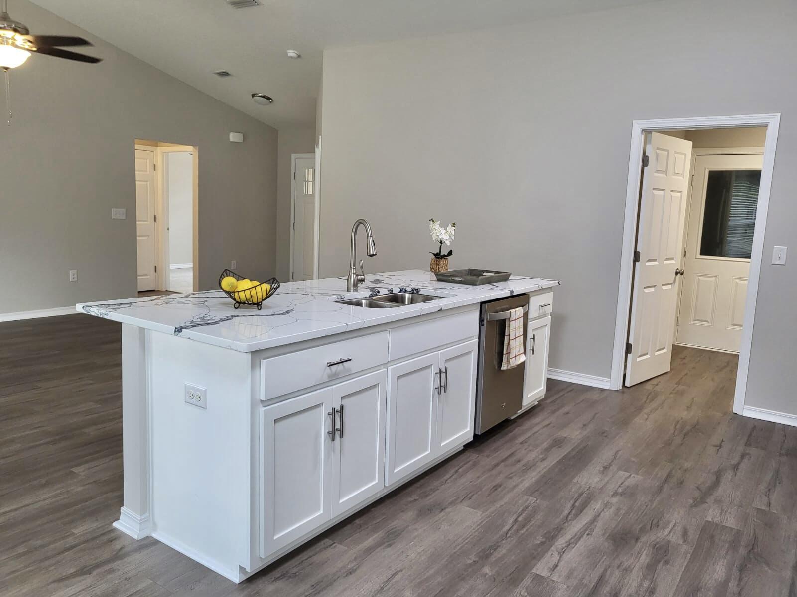 6330 Possum Ridge Road Crestview, FL 32539 - Photo 8 of 22 a kitchen with a granite countertop white cabinets and a sink