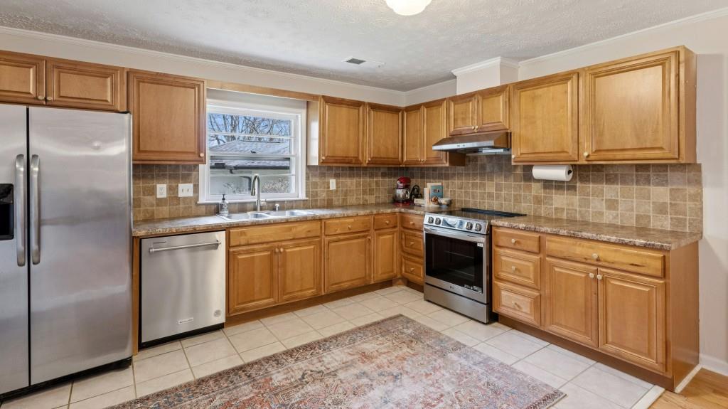 3972 North Peachtree Road Atlanta, GA 30341 - Photo 13 of 28 a kitchen with stainless steel appliances granite countertop a stove a sink dishwasher a refrigerator and cabinets with wooden floor