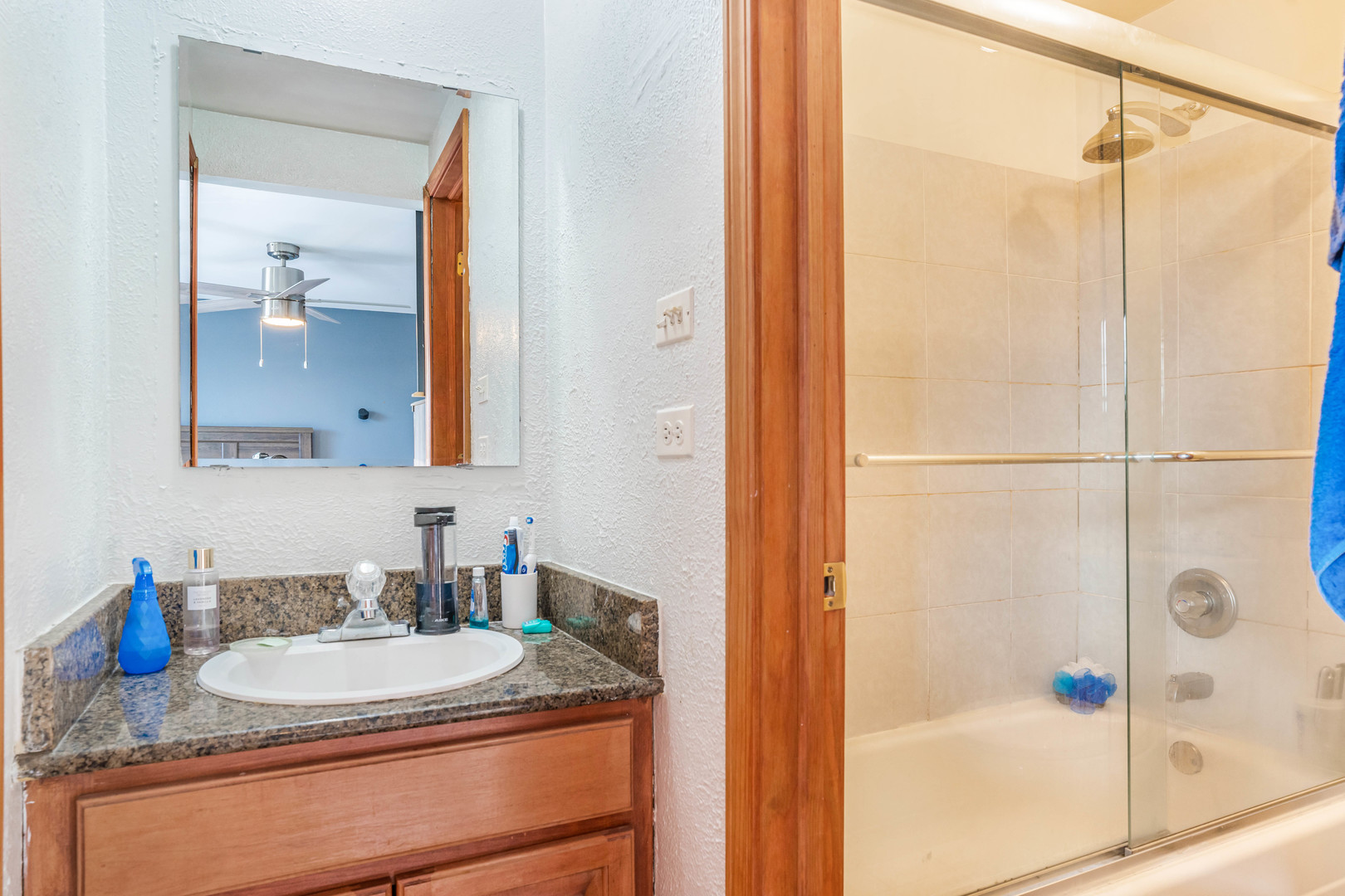 4553 West 56th Street, Unit 204 Chicago, IL 60629 - Photo 11 of 16 a bathroom with a granite countertop sink a mirror and shower