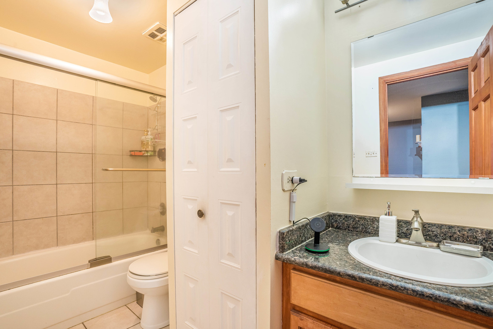4553 West 56th Street, Unit 204 Chicago, IL 60629 - Photo 14 of 16 a bathroom with a granite countertop sink toilet mirror and shower