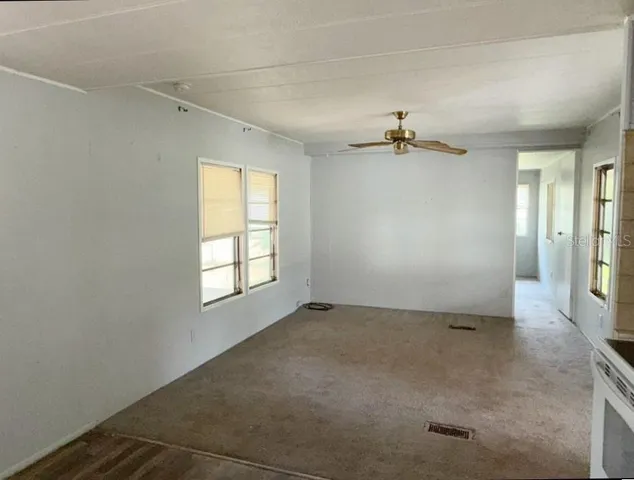 a view of a livingroom with a window and a ceiling fan