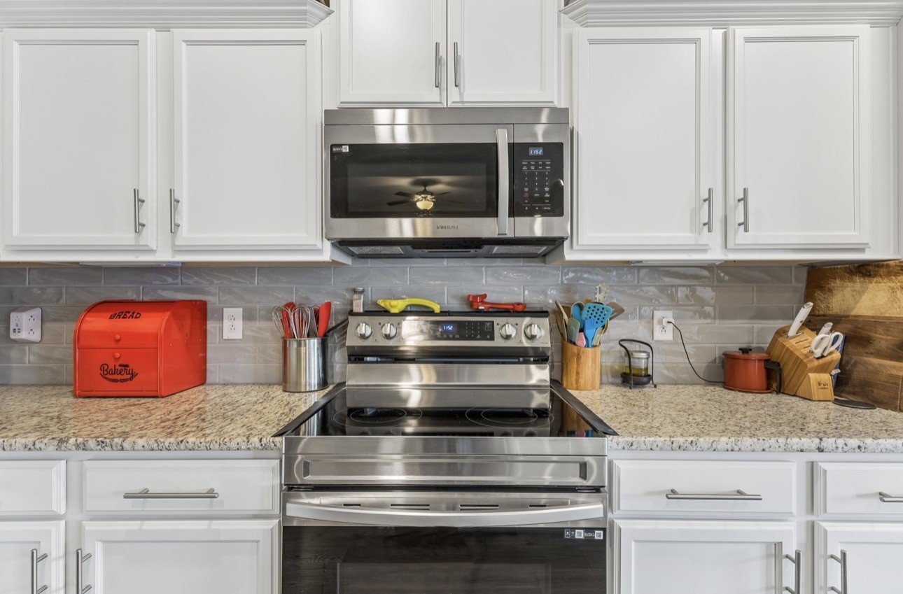 413 Ruby Cate Way Murfreesboro, TN 37128 - Photo 15 of 31 a kitchen with granite countertop white cabinets and stainless steel appliances