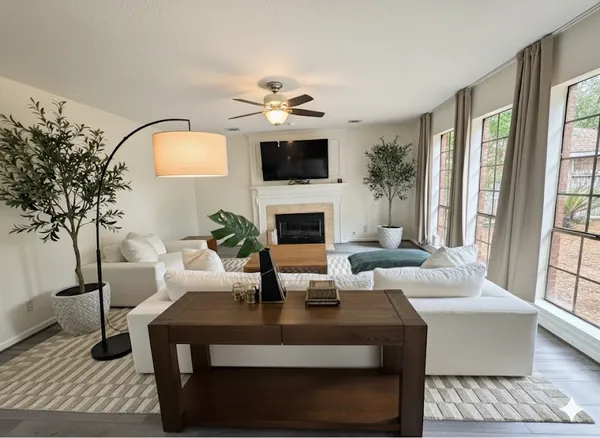 a living room with furniture a fireplace and a flat screen tv
