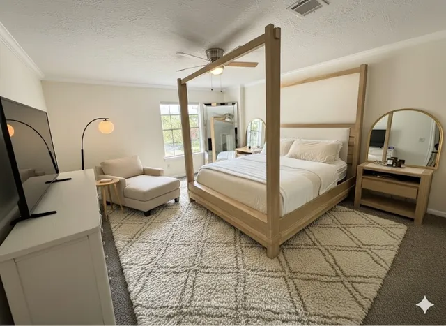 a bedroom with bed couch and window