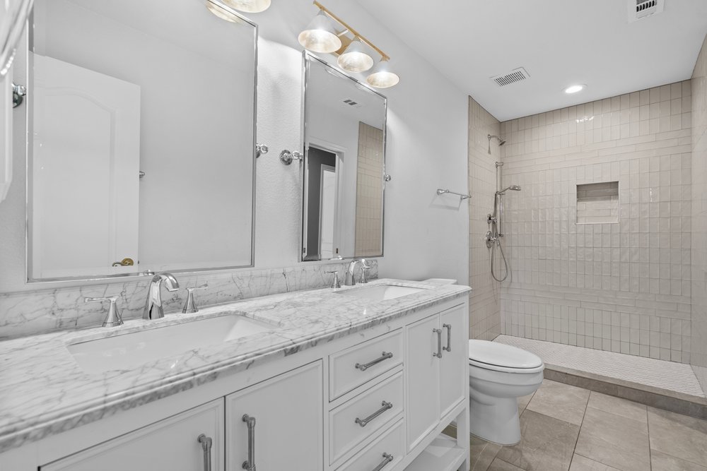 1815 Rue De St Tropez Austin, TX 78746 - Photo 37 of 40 Dual vanity with a stone countertop, chrome fixtures, and undermount sinks