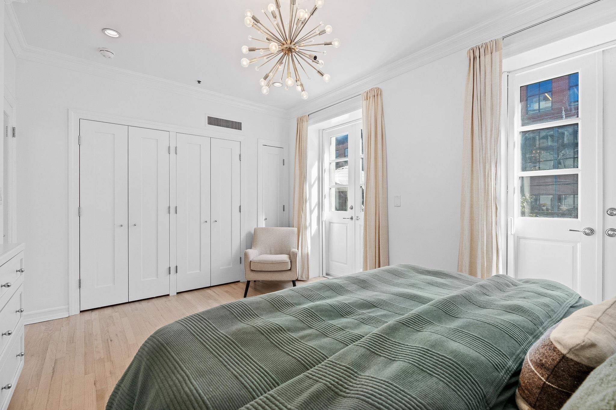 600 Hudson Street, Unit 2B Hoboken, NJ 07030 - Photo 15 of 20 a bedroom with a bed and a chandelier
