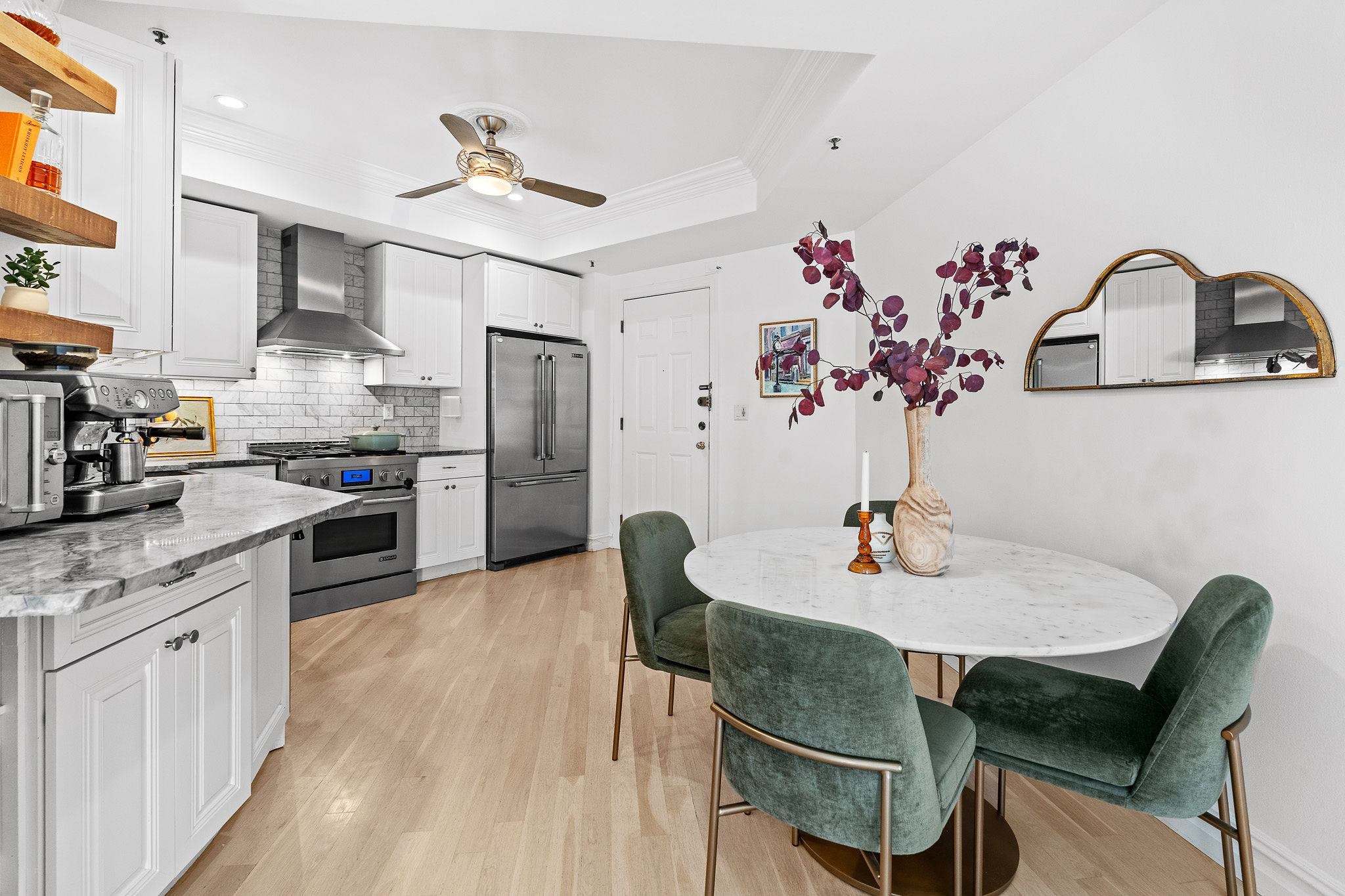 600 Hudson Street, Unit 2B Hoboken, NJ 07030 - Photo 6 of 20 a kitchen with stainless steel appliances granite countertop a dining table chairs stove and white cabinets