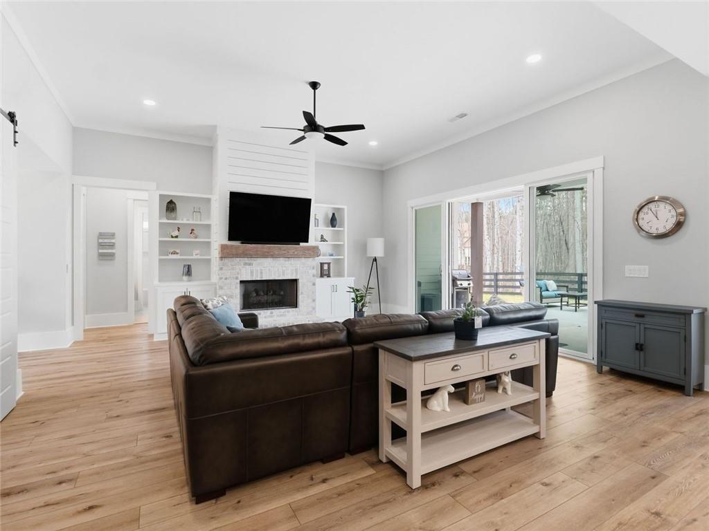 877 Arnold Mill Road Woodstock, GA 30188 - Photo 13 of 62 a living room with furniture a fireplace and a flat screen tv