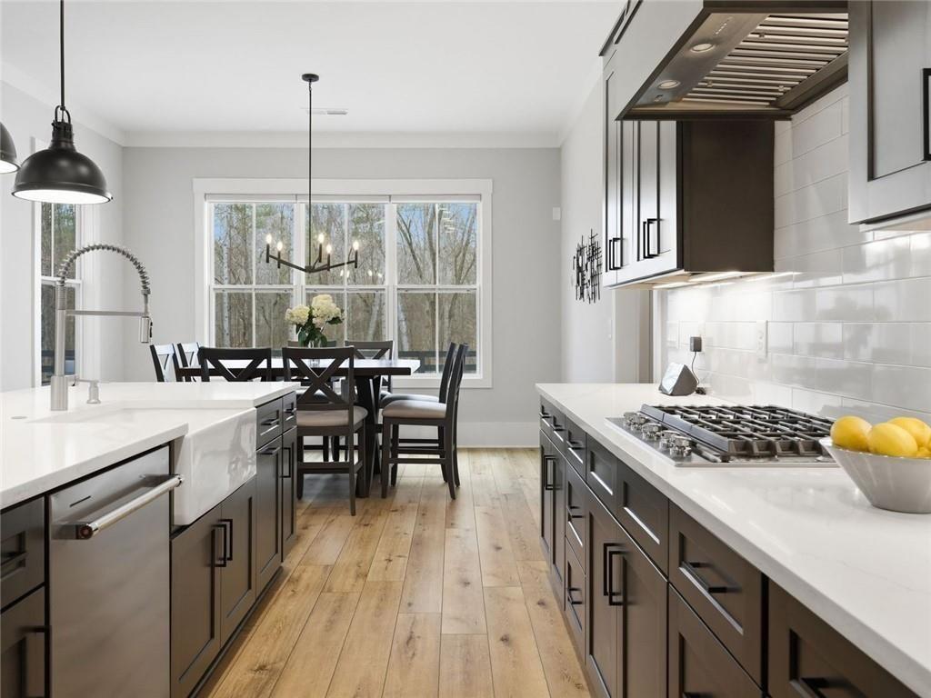877 Arnold Mill Road Woodstock, GA 30188 - Photo 19 of 62 a kitchen with a stove a sink a dining table and chairs