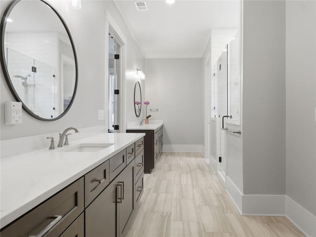 877 Arnold Mill Road Woodstock, GA 30188 - Photo 31 of 62 a bathroom with a sink a mirror a vanity and a shower