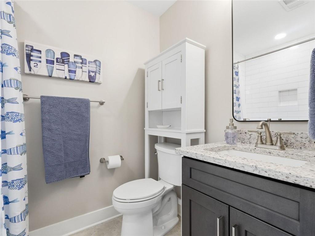 877 Arnold Mill Road Woodstock, GA 30188 - Photo 48 of 62 a bathroom with a granite countertop toilet sink and mirror