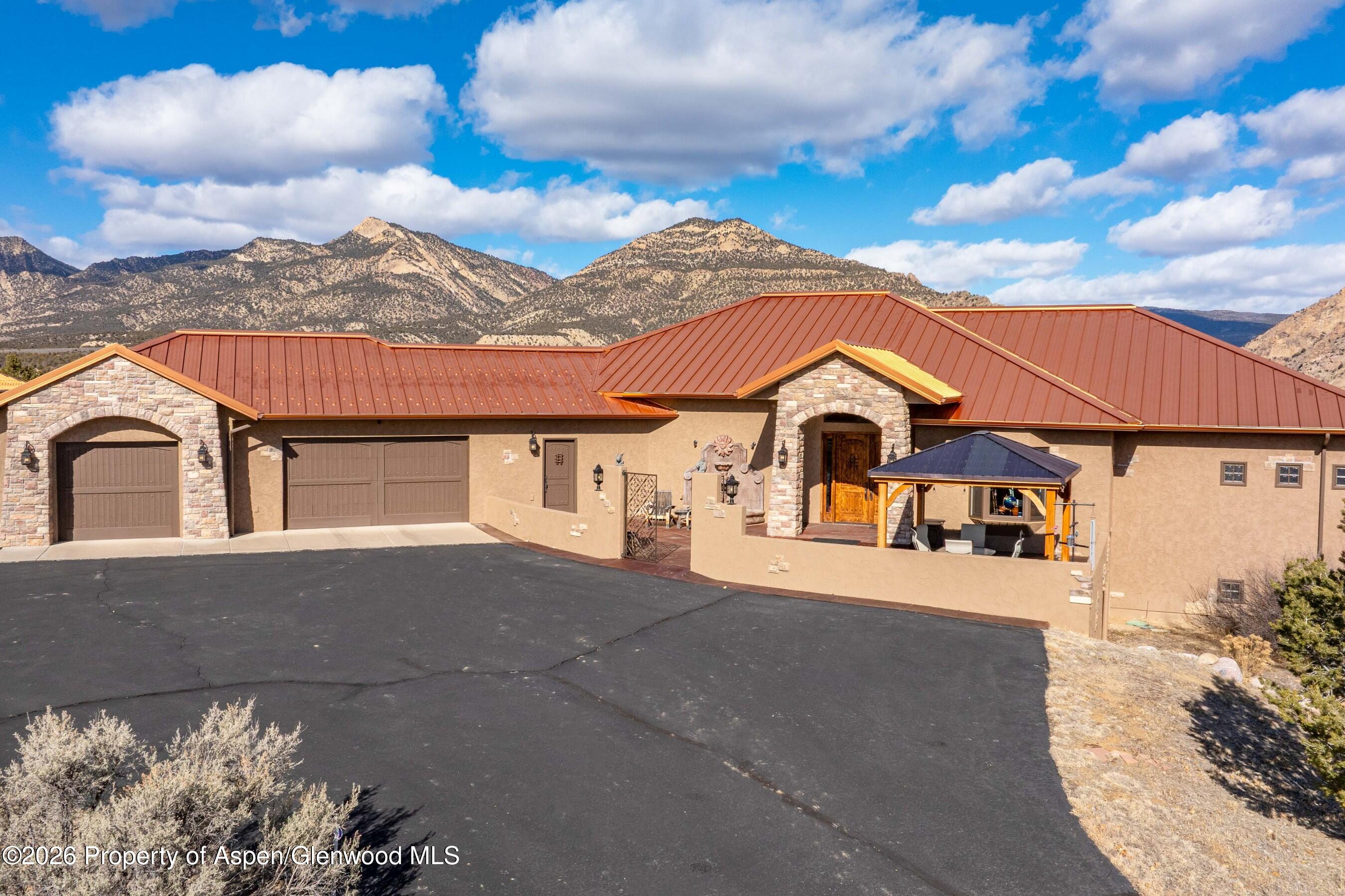 966 Mesa Drive Rifle, CO 81650 - Photo 6 of 54 a view of a white house with a large tree and a yard
