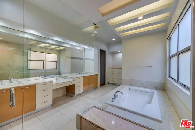 a bathroom with a tub sink and mirror