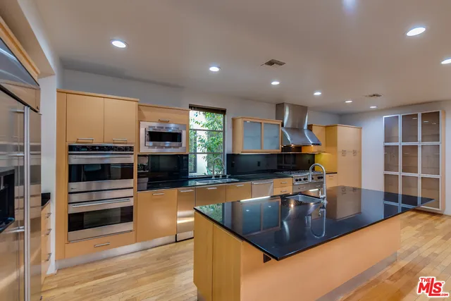 a kitchen with stainless steel appliances granite countertop a sink a stove and a microwave