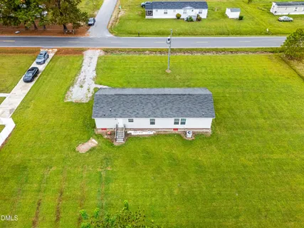 a view of a house with a big yard and large trees
