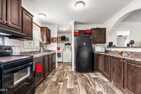 a kitchen with stainless steel appliances granite countertop a refrigerator stove and a sink