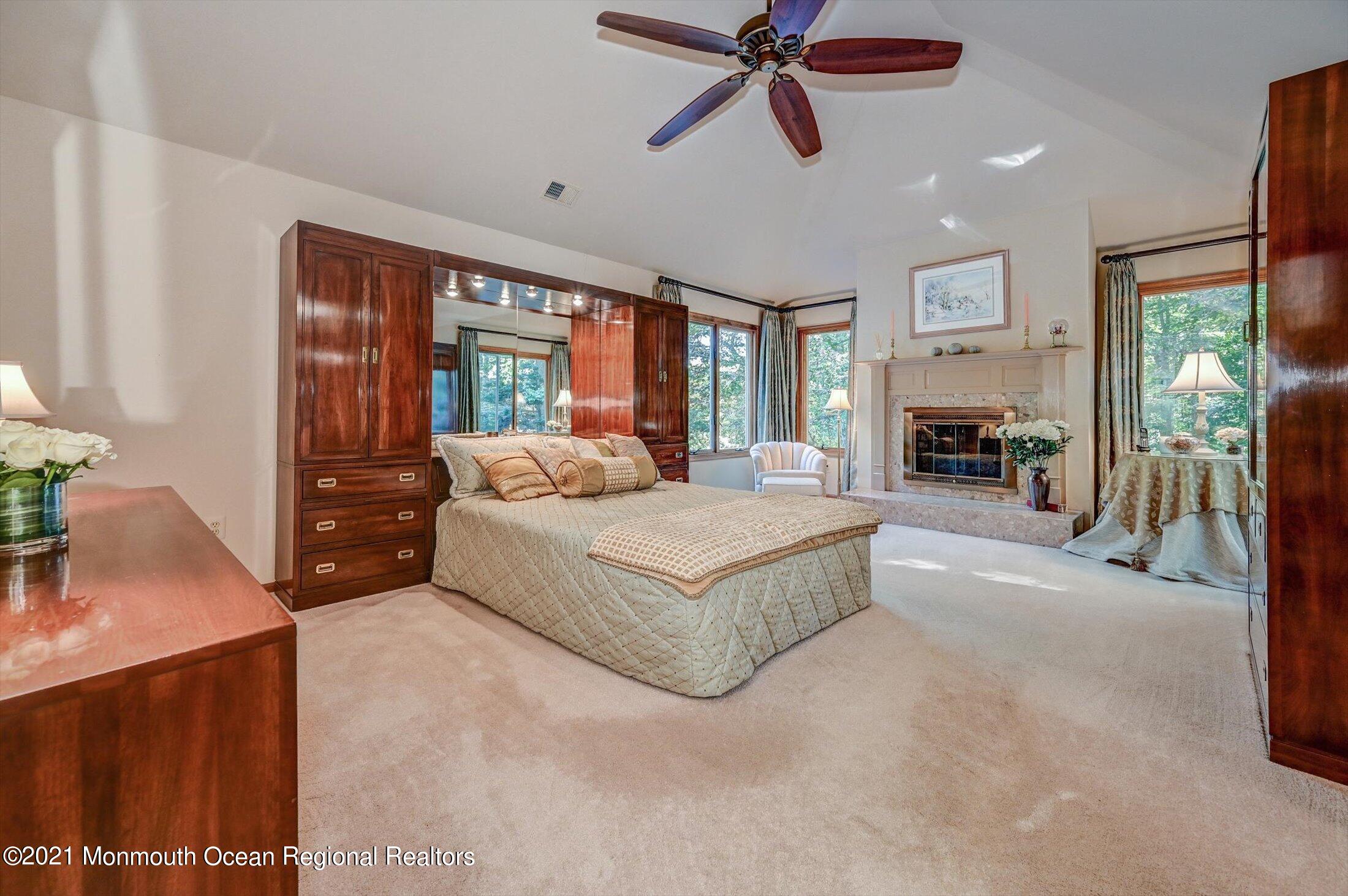 10 Crowfield Lane Holmdel, NJ 07733 - Photo 20 of 52 a bedroom with a large bed and a chandelier
