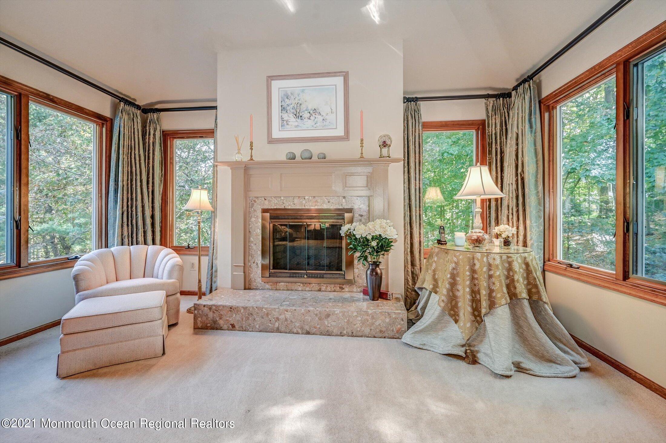 10 Crowfield Lane Holmdel, NJ 07733 - Photo 22 of 52 a living room with furniture a flat screen tv and a fireplace