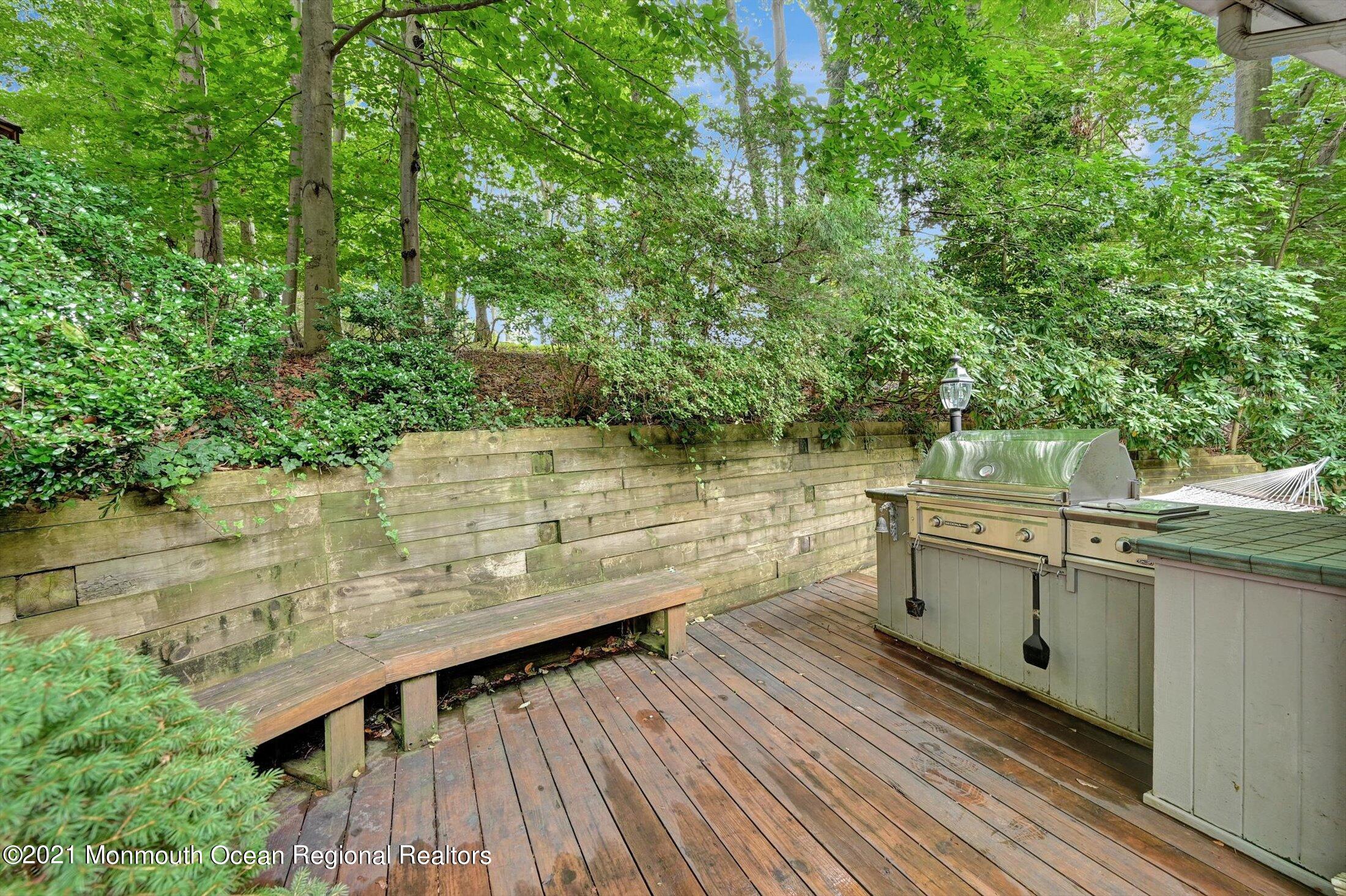 10 Crowfield Lane Holmdel, NJ 07733 - Photo 39 of 52 a view of a patio with table and chairs with wooden floor and fence