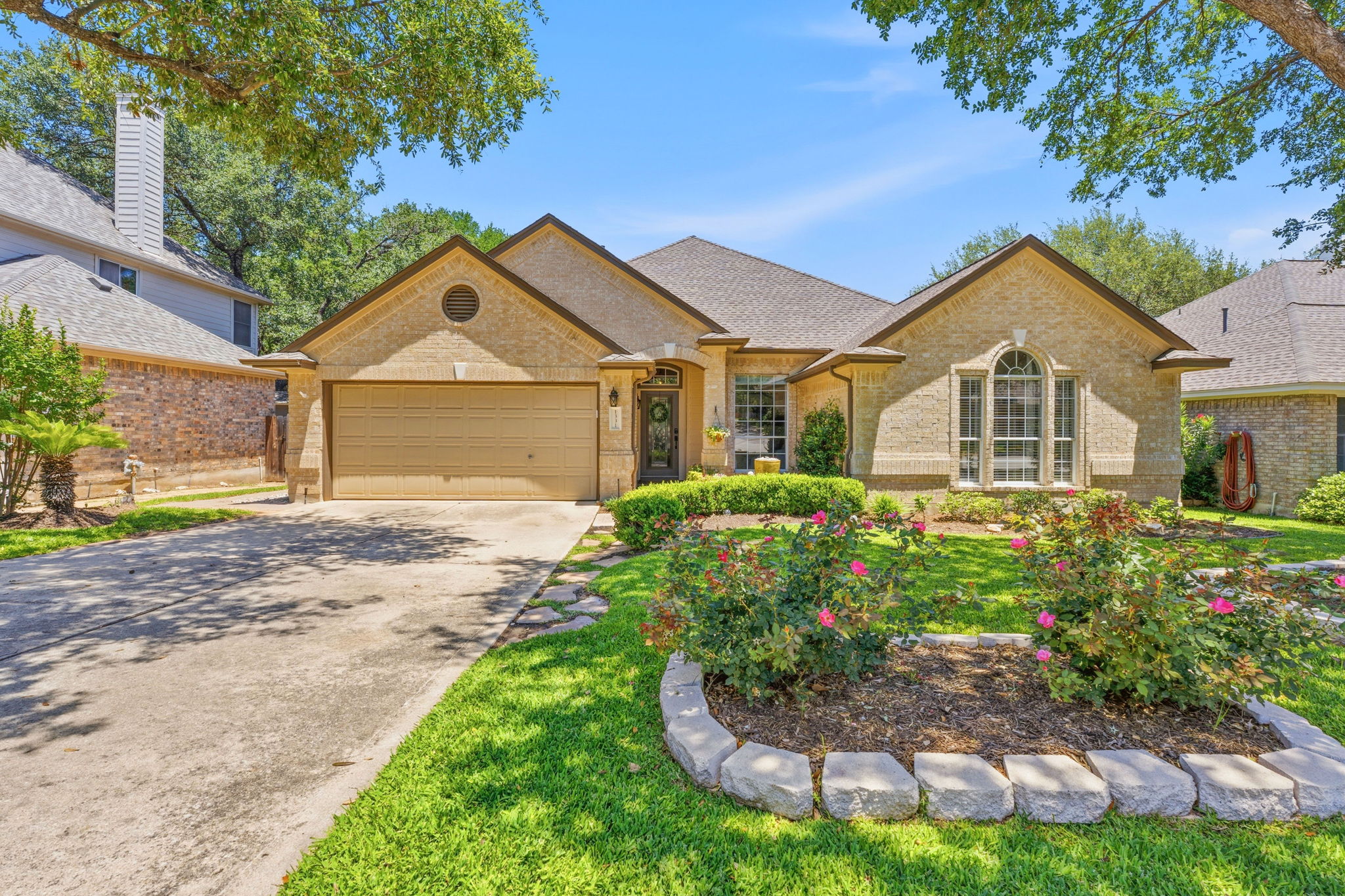 1331 Fall Creek Loop Cedar Park, TX 78613 - Photo 1 of 1 Brick exterior with a prominent arched window and a two-car garage