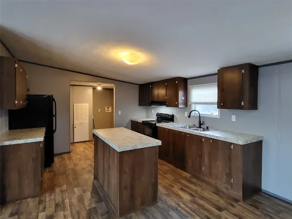 a large kitchen with stainless steel appliances a sink stove and refrigerator