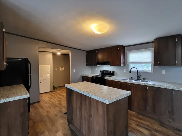 a kitchen with a sink a stove a refrigerator and cabinets