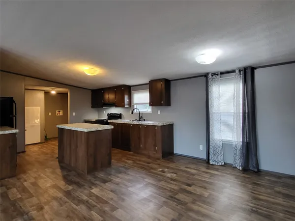 a kitchen with stainless steel appliances granite countertop a refrigerator a sink dishwasher and a oven with wooden floor