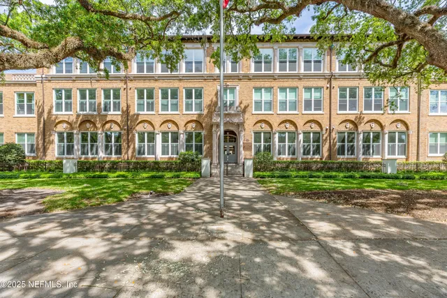 a front view of a residential apartment building with a yard