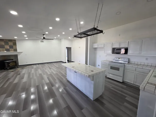 a kitchen with granite countertop a stove a sink and a refrigerator