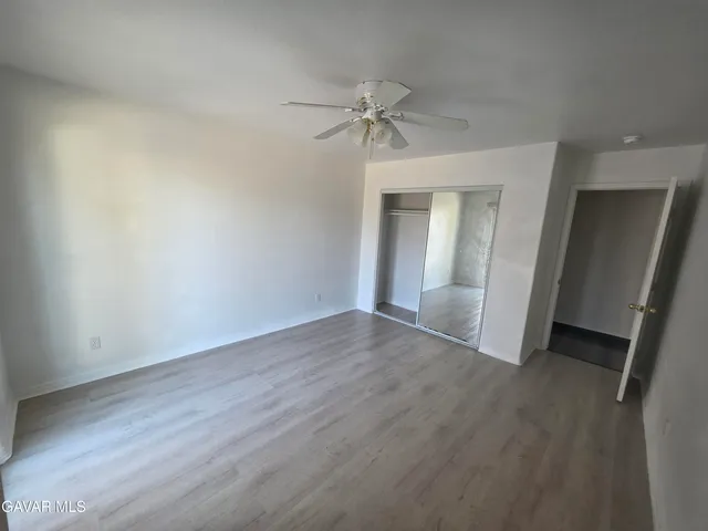 a view of a livingroom with a chandelier fan and closet area
