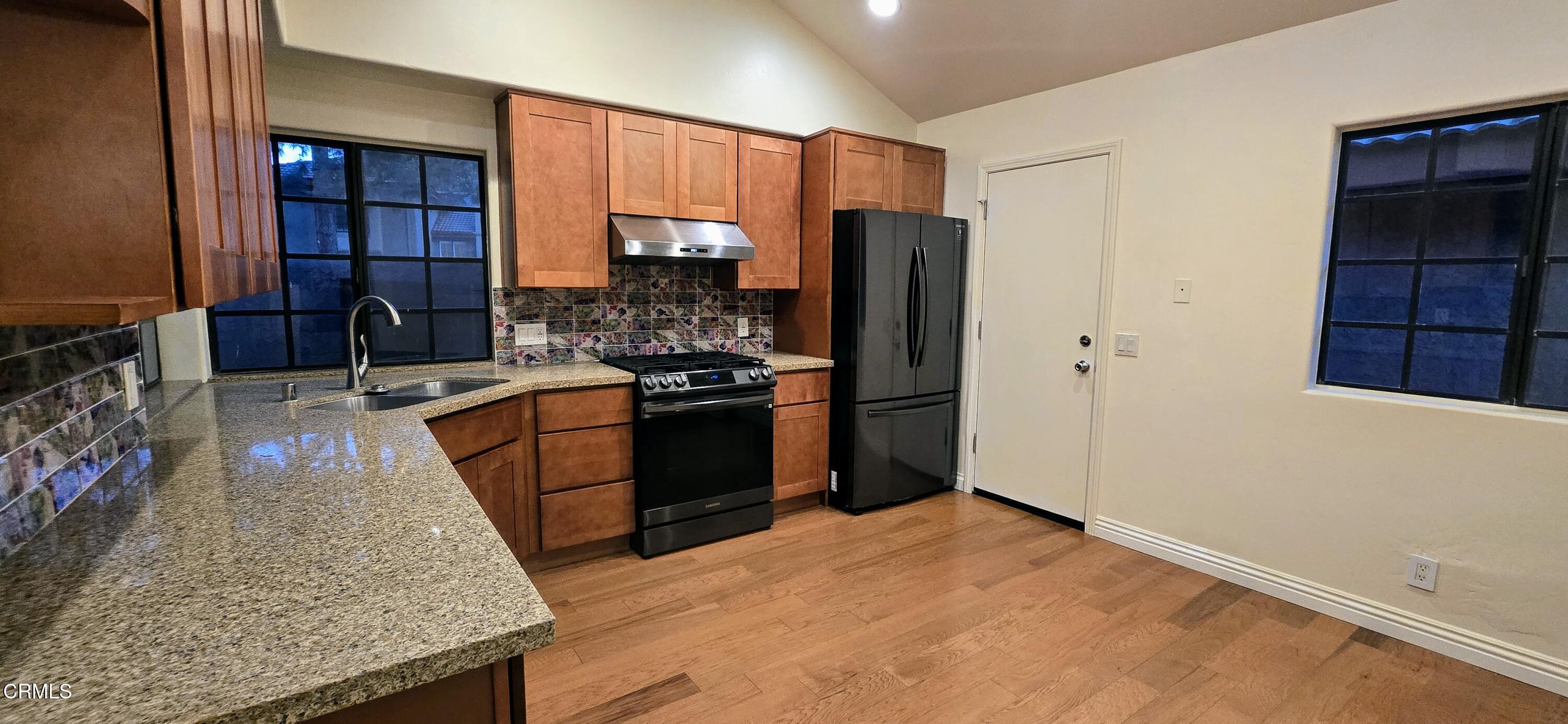 3701 Via Pacifica Walk Oxnard, CA 93035 - Photo 17 of 49 a kitchen with stainless steel appliances granite countertop a stove refrigerator sink and cabinets
