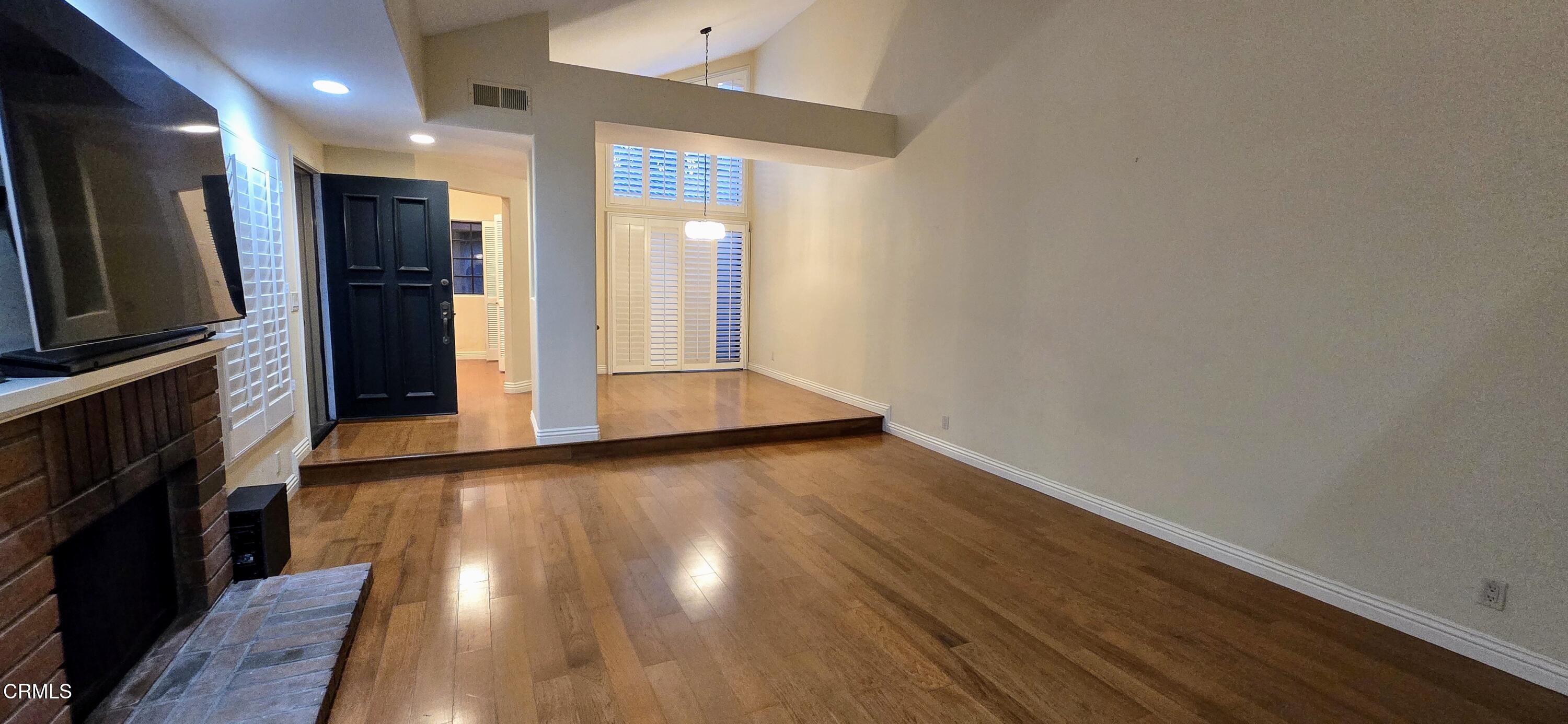 3701 Via Pacifica Walk Oxnard, CA 93035 - Photo 6 of 49 an empty room with wooden floor and a fireplace