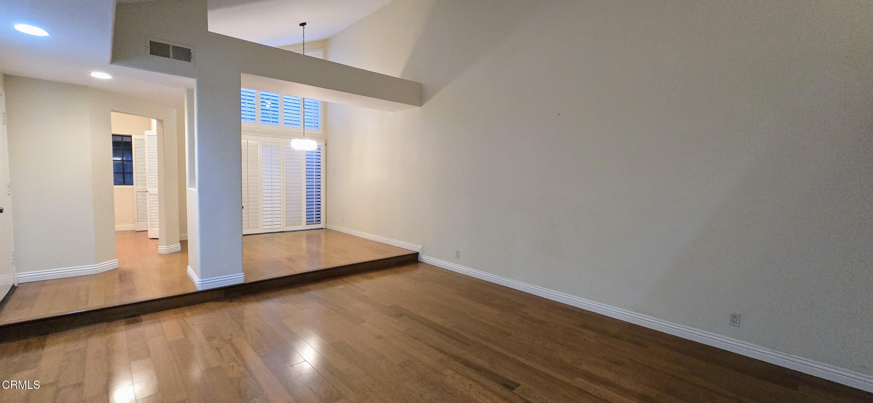 3701 Via Pacifica Walk Oxnard, CA 93035 - Photo 7 of 49 a view of an empty room with wooden floor and a window