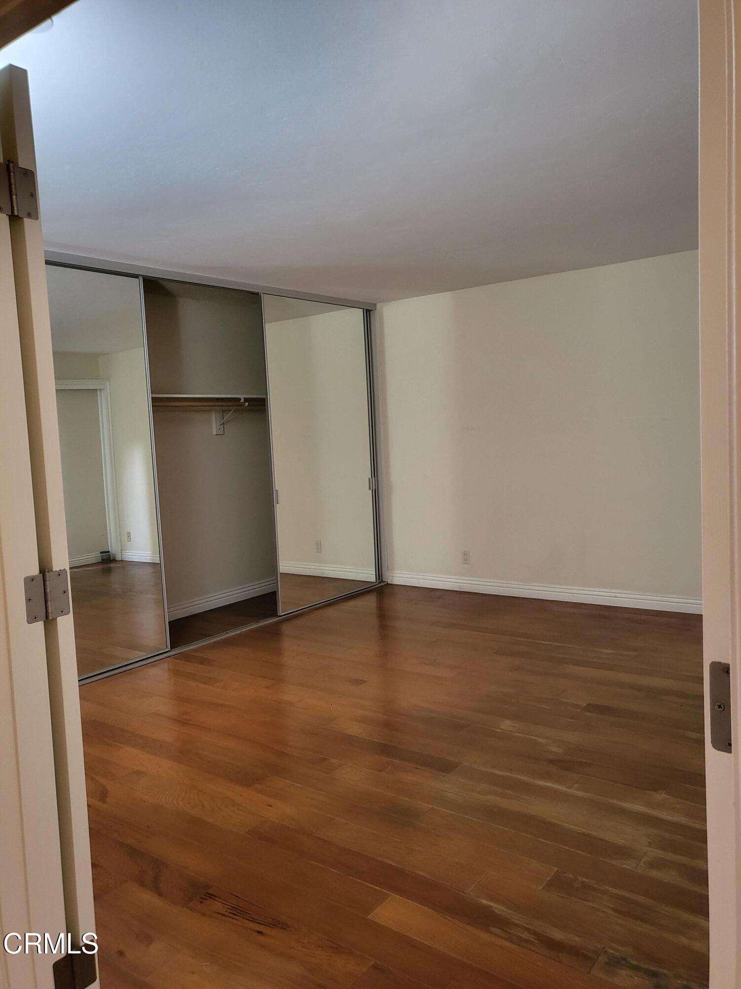 3701 Via Pacifica Walk Oxnard, CA 93035 - Photo 10 of 49 a view of an empty room with wooden floor and a window